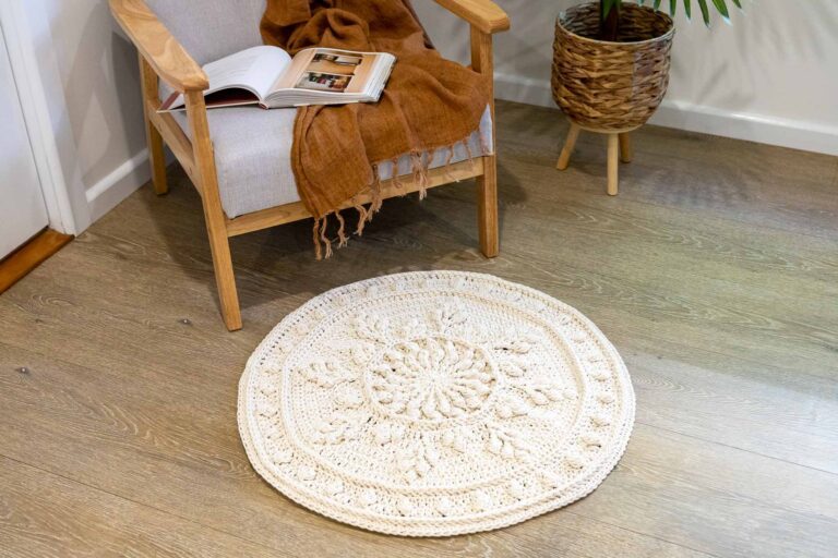 Round crochet floor rug in front of reading chair.