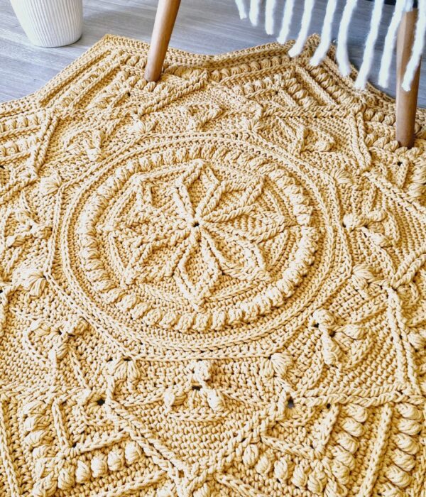 Crochet floor rug in front of chair.