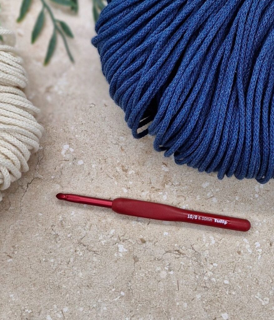 Natural and blue crochet cord with a red crochet hook.