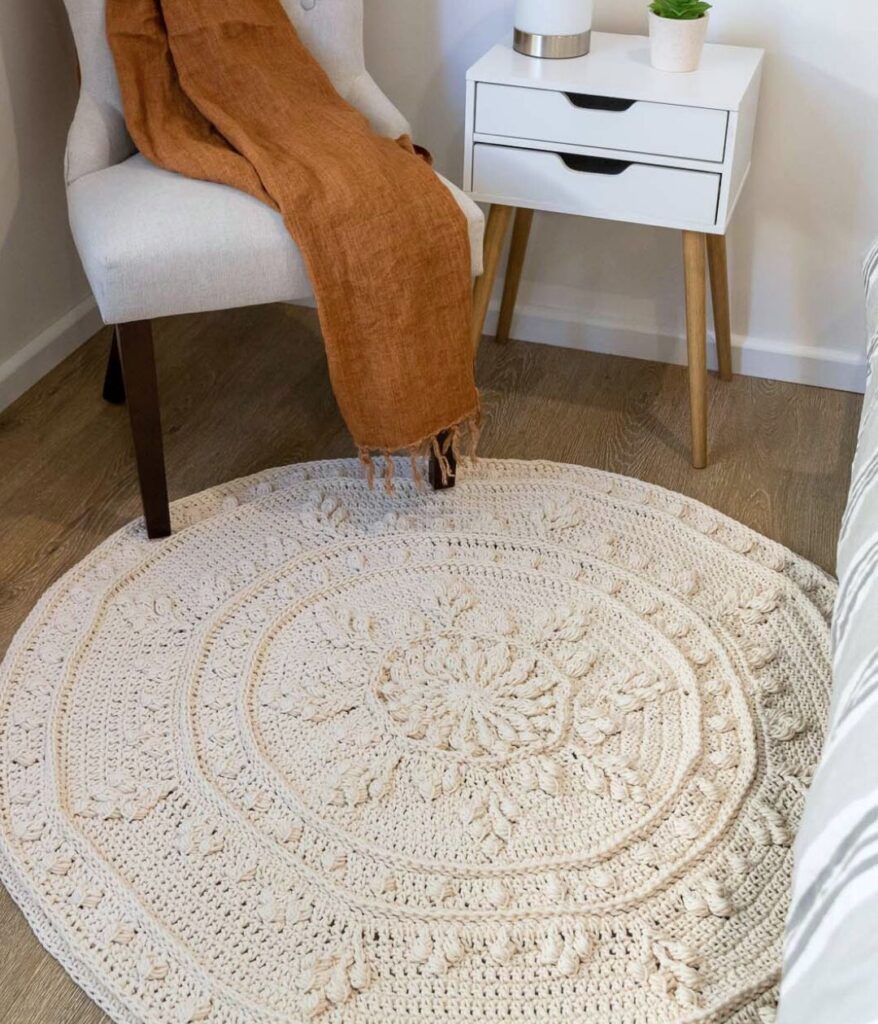 Crochet floor rug in front of chair.