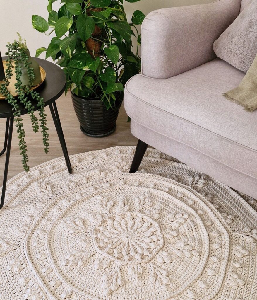 White crochet floor rug next to a chair and table.