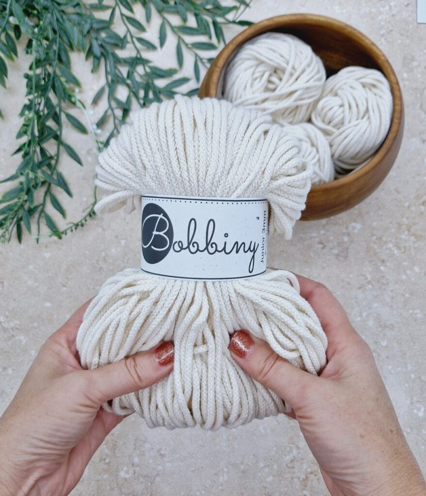 Hands holding Bobbiny crochet cord.